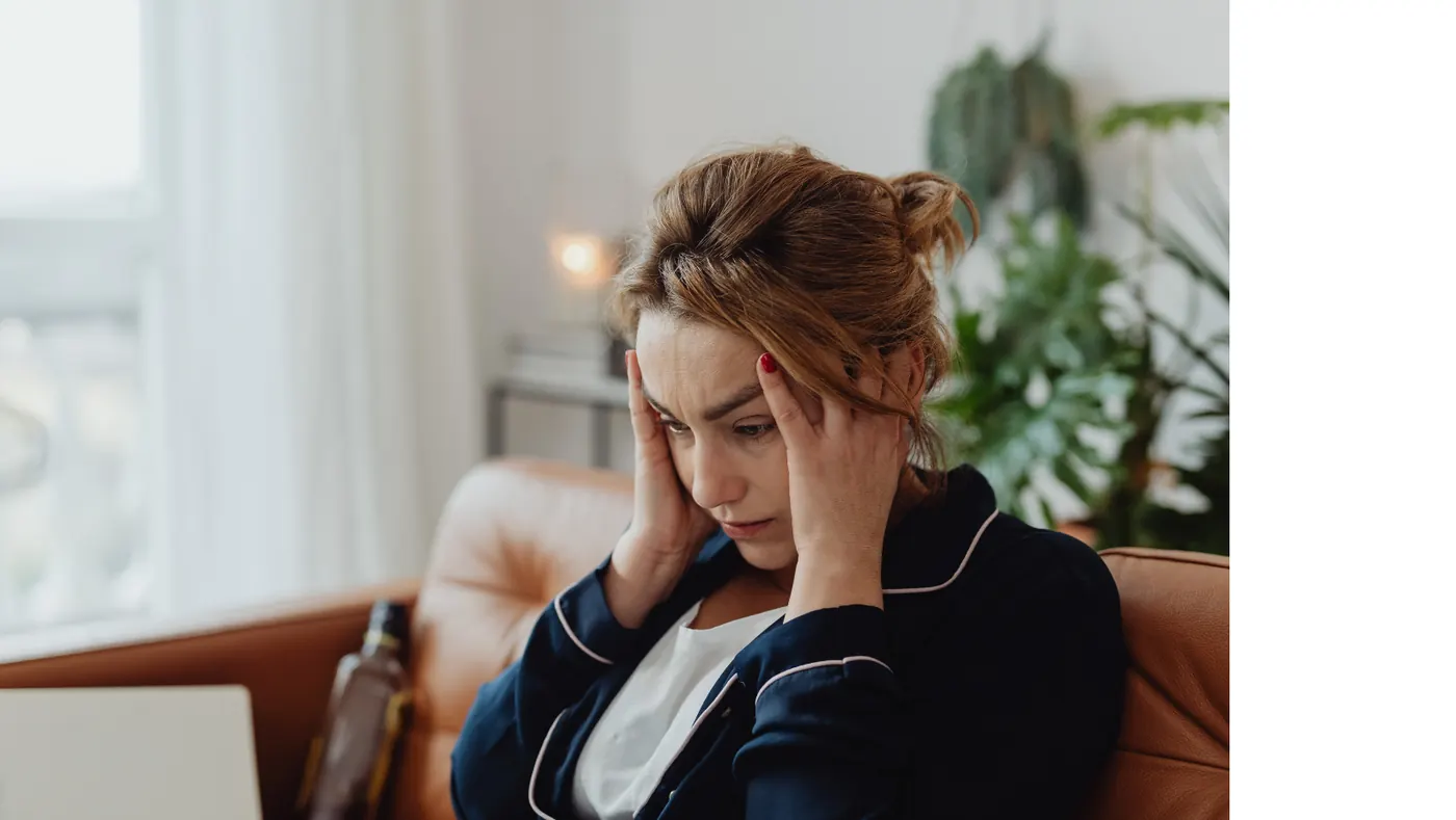 Erschöpfte Frau auf einer Couch – Symbolbild für chronischen Stress